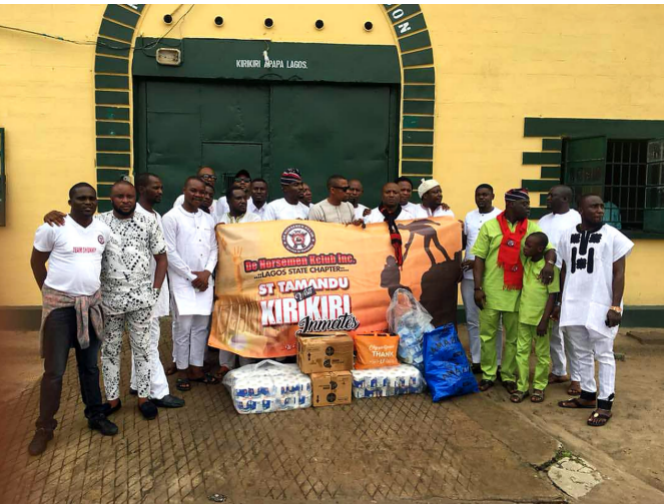 Members of ST Tamandu Marine Patrol gathered at the entrance of Kirikiri Maximum Security Prison, Apapa, with welfare donation items ahead of the visit. The St Tamandu banner reads: “ST Tamandu Visits Kirikiri Inmates.”