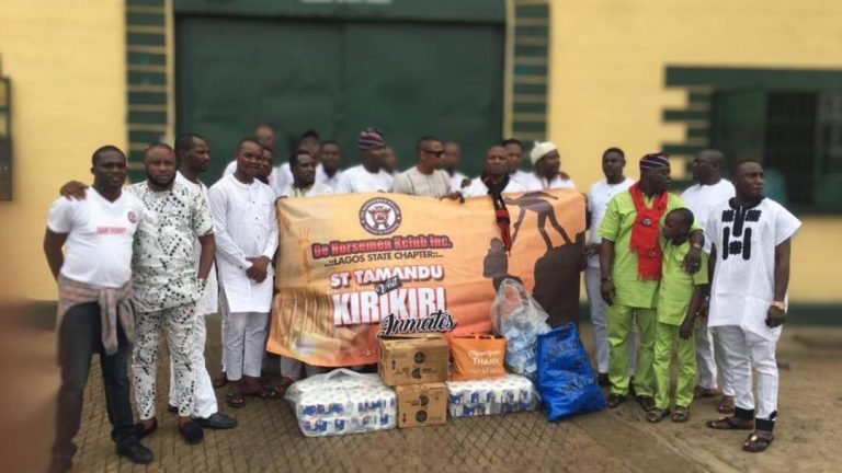 Members of ST Tamandu Marine Patrol gathered at the entrance of Kirikiri Maximum Security Prison, Apapa, with welfare donation items ahead of the visit. The St Tamandu banner reads: “ST Tamandu Visits Kirikiri Inmates.”